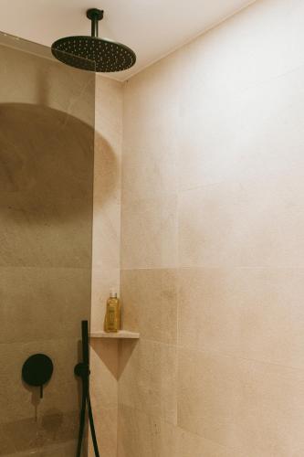 a bathroom with a shower with a light fixture at Rondaia, a Winery & Fincahotel-Agroturismo in Tramuntana in Esporles
