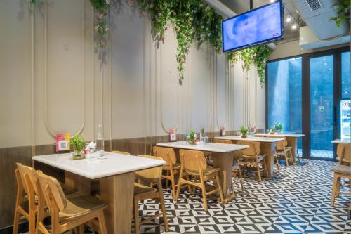 a restaurant with tables and chairs and a flat screen tv at Cosy Grand, Chanakyapuri by The Cosy Hotels in New Delhi