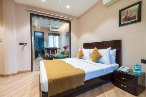 a bedroom with a large bed with a yellow blanket at Cosy Grand, Chanakyapuri by The Cosy Hotels in New Delhi