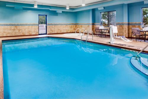 a pool in a hotel room with blue walls at Holiday Inn Express Hotel & Suites Coralville by IHG in Coralville