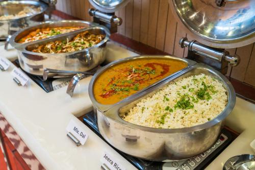 three pots of food sitting on a counter at Cosy Grand, Chanakyapuri by The Cosy Hotels in New Delhi