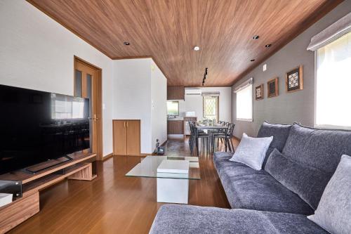 a living room with a couch and a flat screen tv at TOCORO Mt Fuji Shizuku in Fujikawaguchiko