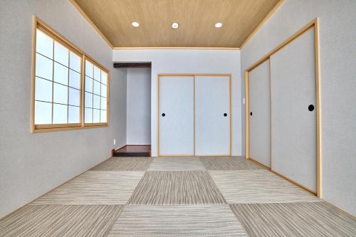 an empty room with two doors and a window at TOCORO Mt Fuji Shizuku in Fujikawaguchiko