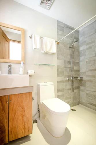 a bathroom with a toilet and a sink and a shower at Zuzuni Boutique Hotel in Boracay