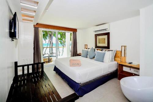 a bedroom with a large bed and a window at Zuzuni Boutique Hotel in Boracay