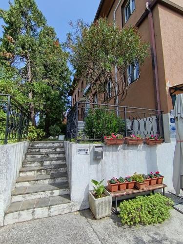 a staircase leading to a house with potted plants at Hotel Locanda Gaia in Muggia
