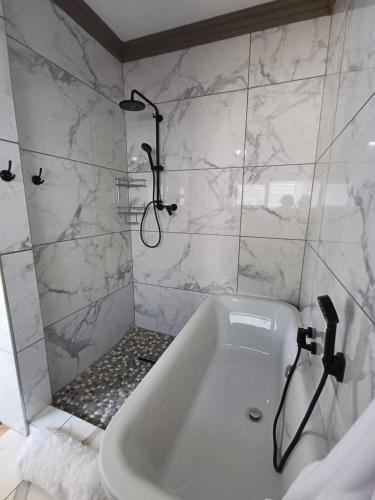 a white bathroom with a shower and a tub at De Witte Huis in Bethlehem