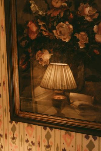 a painting of a lamp in front of a painting of roses at Rondaia, a Winery & Fincahotel-Agroturismo in Tramuntana in Esporles