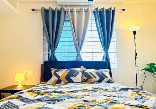 a bedroom with a bed with blue curtains and a window at Evara Luxury Living Central 3BHK near HITEC City in Hyderabad