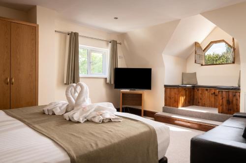 a bedroom with a bed with a towel animal on it at The Cathedral Hotel in Lichfield