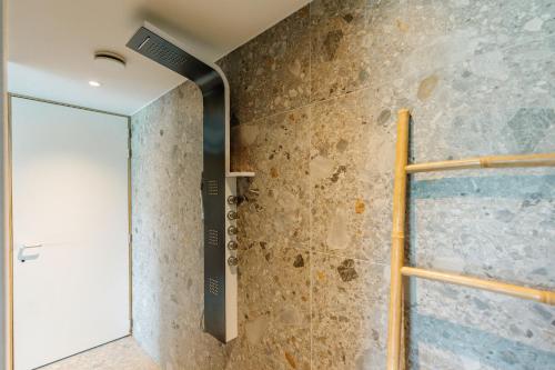 a shower with a glass door in a bathroom at La Ferme d'Auwez - Arbre de vie - Gîte 4 pers avec piscines et sauna in Ciney