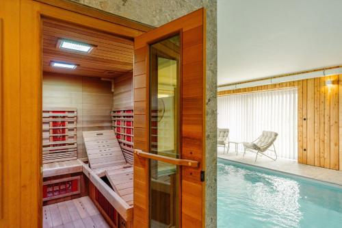 a house with a swimming pool next to a house at La Ferme d'Auwez - Arbre de vie - Gîte 4 pers avec piscines et sauna in Ciney