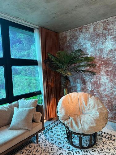 a living room with a couch and a chair at Sky Garden Hotel Tam Dao Phu Tho in Tam Ðảo