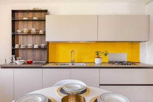 a kitchen with white cabinets and a sink and a table at Casa Pradiei Dolomiti View in Cavareno