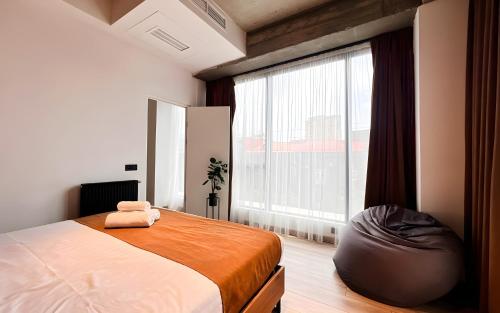 a bedroom with a bed and a large window at Rooms Apart Hotel by RED in Yerevan