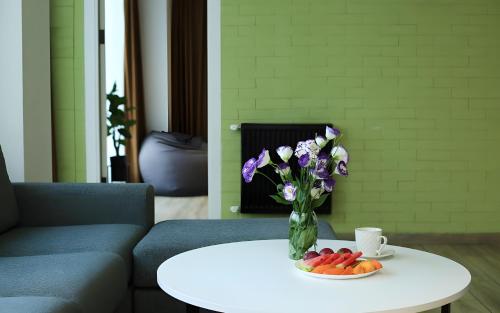 a vase of purple flowers and fruit on a table at Rooms Apart Hotel by RED in Yerevan