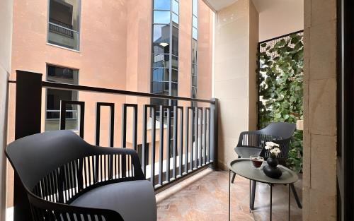 a balcony with chairs and a table and a building at Rooms Apart Hotel by RED in Yerevan