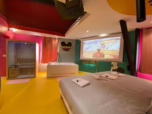 a bedroom with a bed and a projection screen at Capsule Family - Sauna - Jacuzzi - Projecteur - Billard - Nintendo Switch 2 - Filet suspendu in Crespin