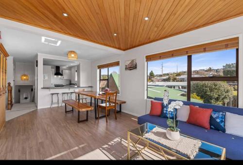 a living room with a blue couch and a table at Spacious retreat with Mountain View in Rotorua