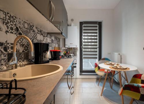 a kitchen with a large sink and a table at Plaza Residence Studio 197 in Bucharest
