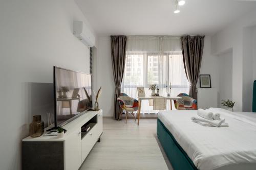 a bedroom with a bed and a tv and a table at Plaza Residence Studio 197 in Bucharest