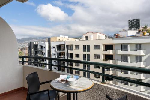 un balcone con tavolo, sedie e edifici di Golden Star AV a Funchal