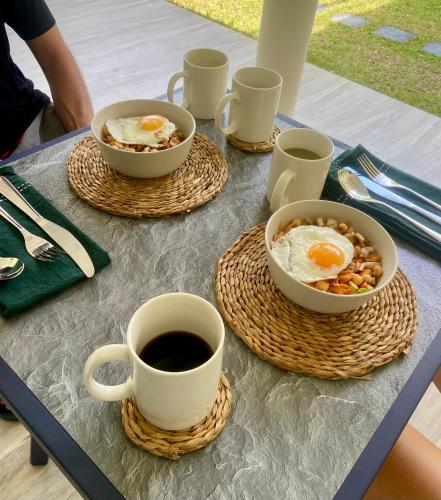a table with two cups of coffee and eggs and nuts at Beachside Stay Steps From Mawella Bay, Tangalle #thisisnotahotel in Mawella