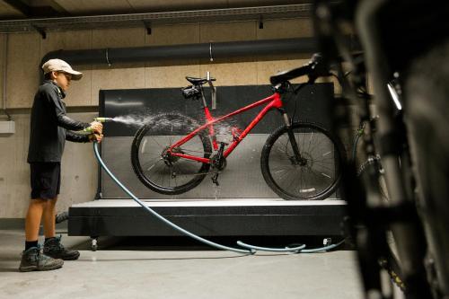 a man washing a bike in a garage at ADEA Lifestyle Suites Fieberbrunn in Fieberbrunn