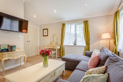 una sala de estar con un sofá y una mesa en Romeo Lodge, en Kingham