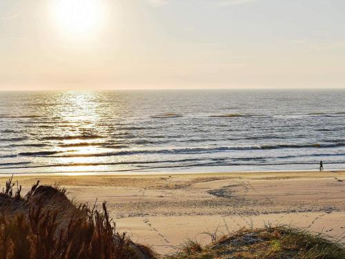 una persona in piedi su una spiaggia vicino all'oceano di 8 person holiday home in Ringkøbing-By Traum a Ringkøbing