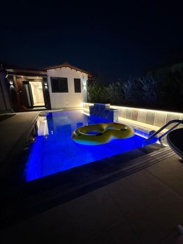 a swimming pool at night with blue lighting at Villa REJA Hamallaj in Draçi
