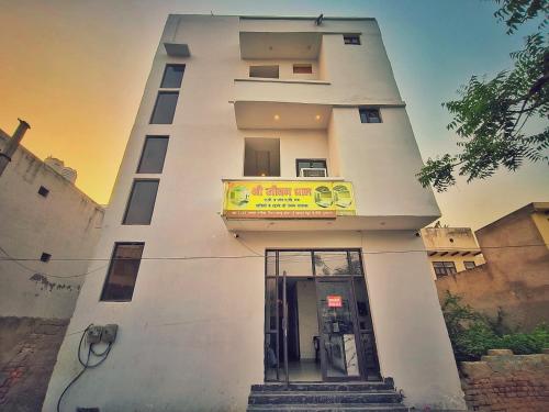 a tall white building with a sign on it at Hotel Shri Jeevan Dham in Vrindāvan