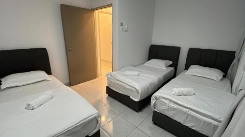 a room with two beds with white sheets at Youth City in Nilai