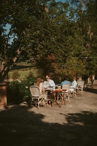 a group of people sitting at a table under a tree at Rondaia, a Winery & Fincahotel-Agroturismo in Tramuntana in Esporles