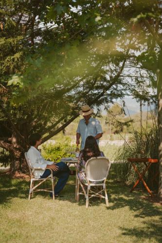 a group of people sitting in chairs under a tree at Rondaia, a Winery & Fincahotel-Agroturismo in Tramuntana in Esporles