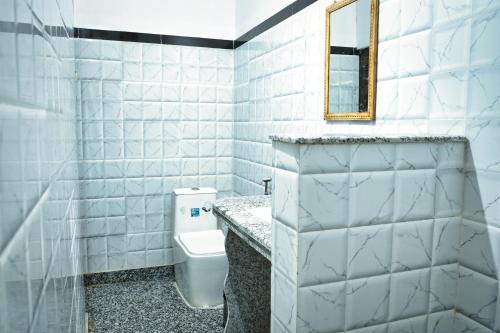 a white bathroom with a toilet and a mirror at Hotel The Surya Jaisalmer in Jaisalmer