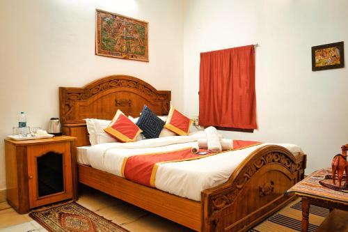 a bedroom with a large wooden bed and a window at Hotel The Surya Jaisalmer in Jaisalmer