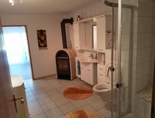 a bathroom with a shower toilet and a stove at Ferienwohnung Brigitte in Volkach