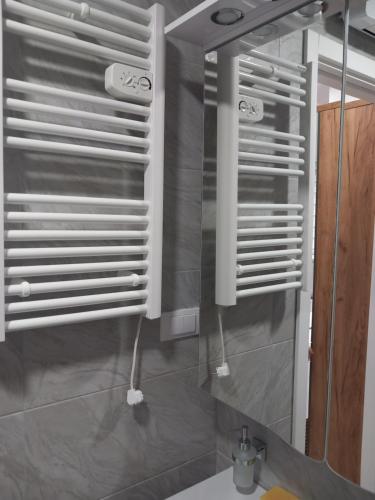 une salle de bain avec des stores blancs sur un miroir dans l'établissement Apartman Anja Divcibare, à Divčibare