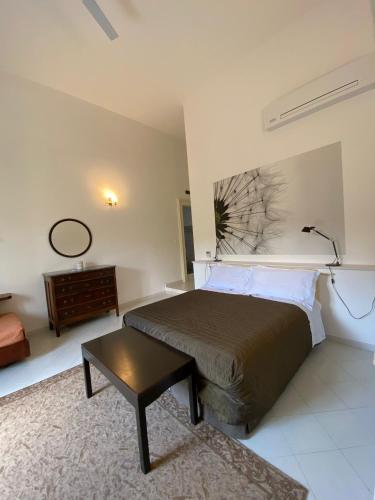 a bedroom with a bed and a table and a mirror at Palazzo Rollo in Lecce