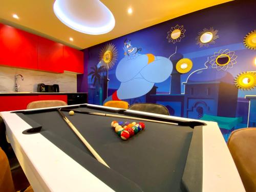 a ping pong table in a room with a mural at Capsule Family - Sauna - Jacuzzi - Projecteur - Billard - Nintendo Switch 2 - Filet suspendu in Crespin