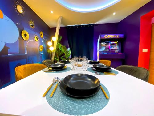 a dining room with a table with black pans on it at Capsule Family - Sauna - Jacuzzi - Projecteur - Billard - Nintendo Switch 2 - Filet suspendu in Crespin