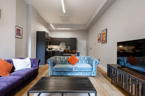 a living room with two blue couches and a tv at Modern City Centre Apartment in Nottingham
