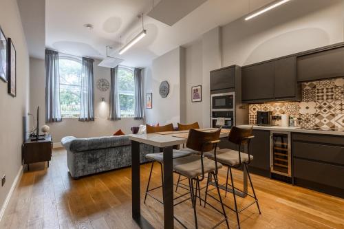 a kitchen and living room with a table and chairs at Modern City Centre Apartment in Nottingham