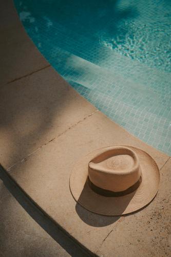 a hat sitting next to a swimming pool at Rondaia, a Winery & Fincahotel-Agroturismo in Tramuntana in Esporles