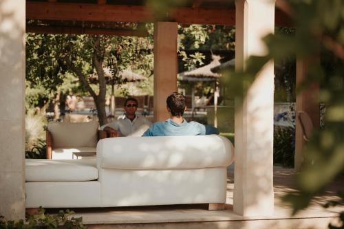 a man sitting on a couch in front of a window at Rondaia, a Winery & Fincahotel-Agroturismo in Tramuntana in Esporles