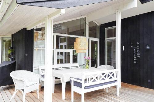 a white table and chairs on a porch at 10017-1-Rorvig-Birkealle-2 in Rørvig