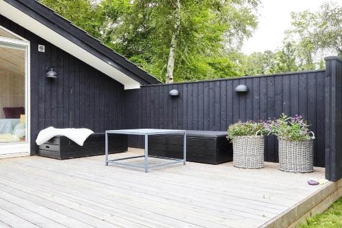 a patio with a table and two potted plants at 10017-1-Rorvig-Birkealle-2 in Rørvig