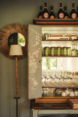 a cabinet with glasses in it with a lamp at Rondaia, a Winery & Fincahotel-Agroturismo in Tramuntana in Esporles