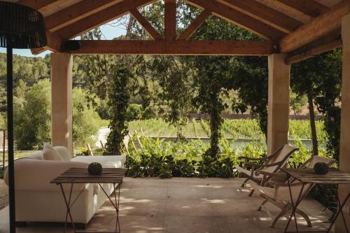 a patio with a white couch and chairs and tables at Rondaia, a Winery & Fincahotel-Agroturismo in Tramuntana in Esporles